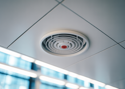 Close-up of a modern fire suppression sprinkler head in a commercial building ceiling, symbolizing safety and protection.