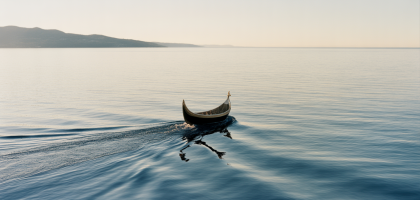 Serene ocean view at sunrise with a ceremonial boat, symbolizing a peaceful full body burial at sea in Southern California.