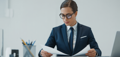 High-quality professional photograph of a business lawyer reviewing SaaS contract documents in a modern office environment with a clean white background