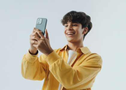 Photorealistic image of a young content creator filming TikTok video with smartphone on white background